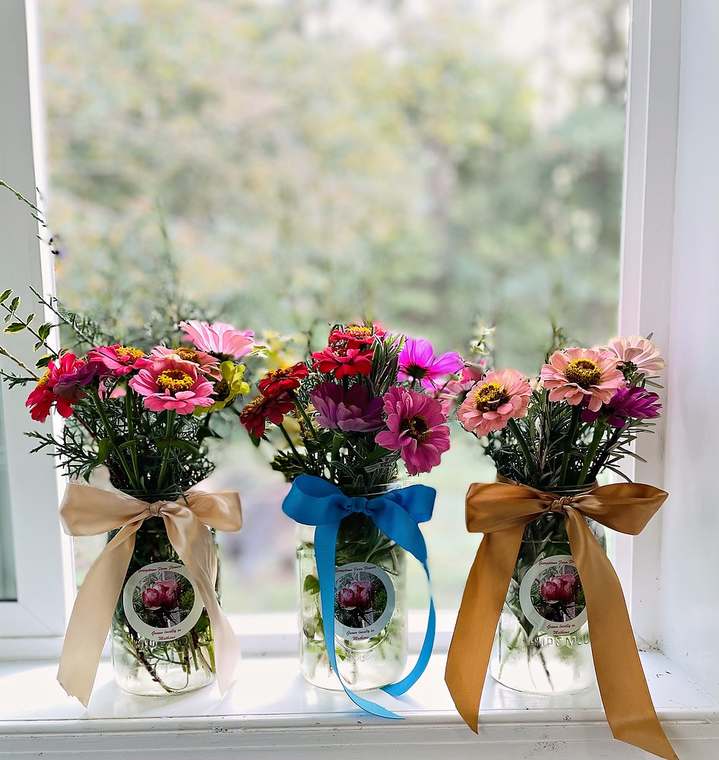 Zinnia bouquets in mason jars with ribbon