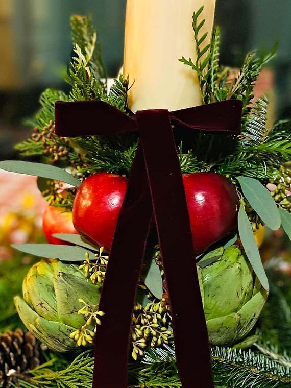 Candle centerpiece with apples, artichokes & velvet ribbon