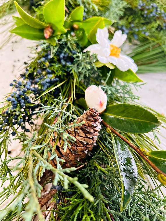 Close-up of juniper, camellia and pinecone garland