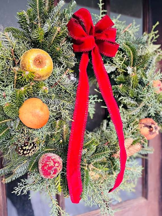 Fir & juniper wreath with gilded fruit & a red velvet bow