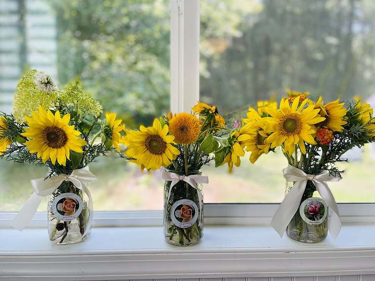 Sunflower bouquets in mason jars with ivory ribbon