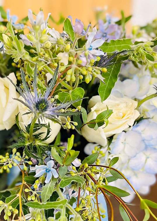 Bridal bouquet of thistle, white roses & blue hydrangea