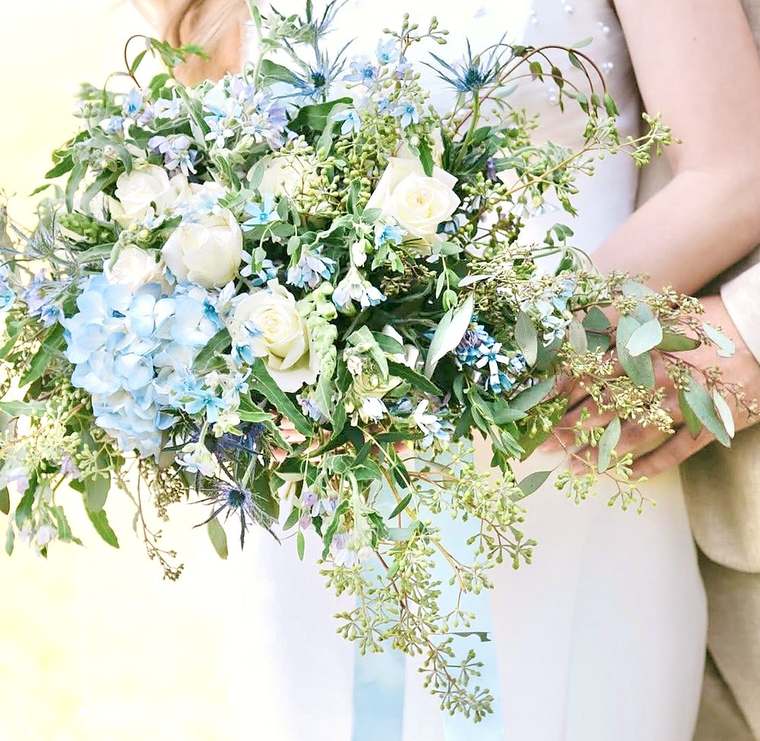 Bridal bouquet of blue hydrangea, white roses, thistle and seeded eucalyptus