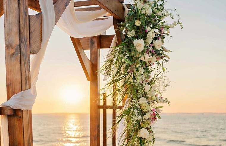 Wedding arch at sunset with cascading white roses