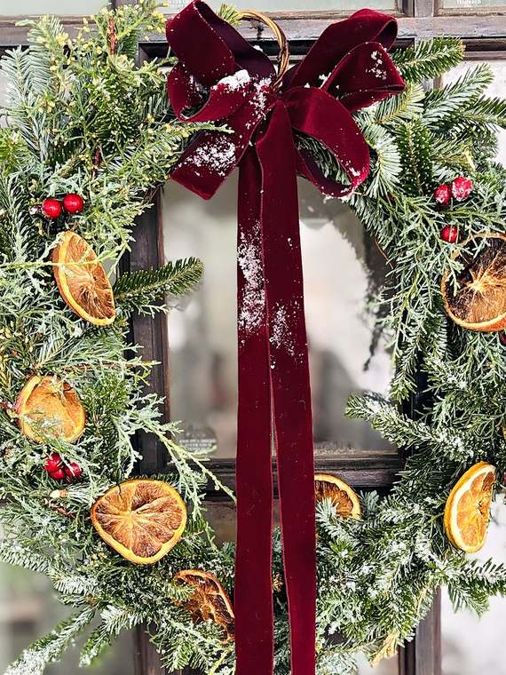 Fir & cedar wreath with dried oranges, red berries & a burgundy velvet bow